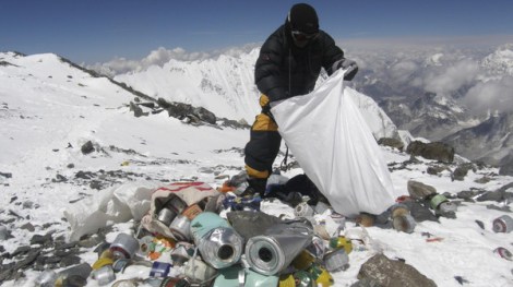 (FILES) This picture taken on May 23, 2010 shows a Nepalese sherpa collecting garbage, left by climbers, at an altitude of 8,000 metres during the Everest clean-up expedition at Mount Everest. Climbers scaling Mount Everest will have to bring back eight kilograms (17.6 pounds) of garbage under new rules designed to clean up the world's highest peak, a Nepalese official said March 3, 2014. AFP PHOTO/Namgyal SHERPA/FILES